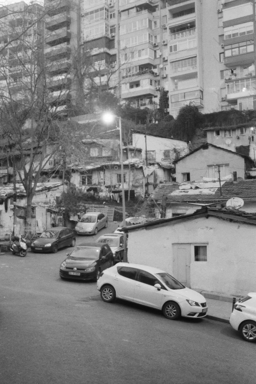 a black and white image of cars parked in a city street