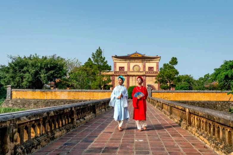 two women walking on a bridge while talking