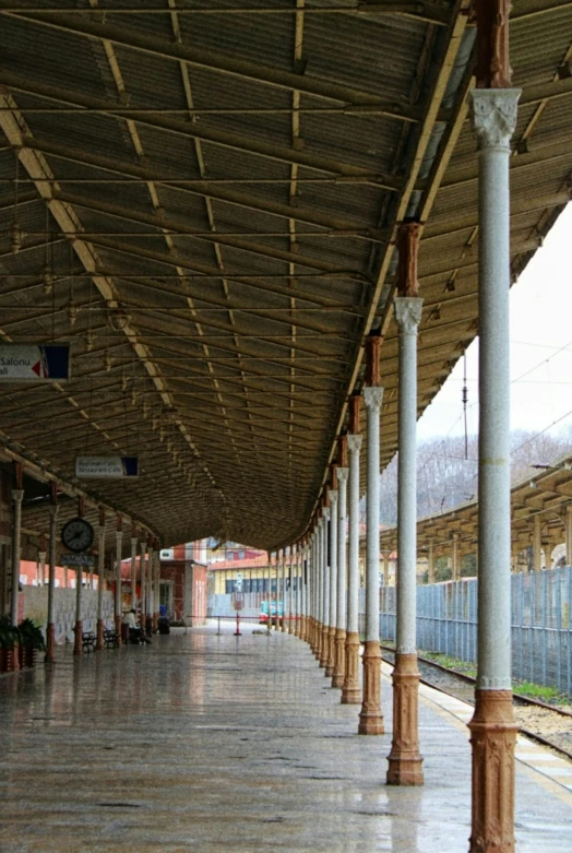 a long covered train station has columns and pillars