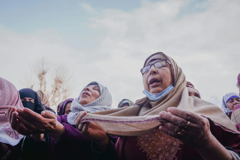 several women dressed in headscarves, scarves, and scarves, some holding soing