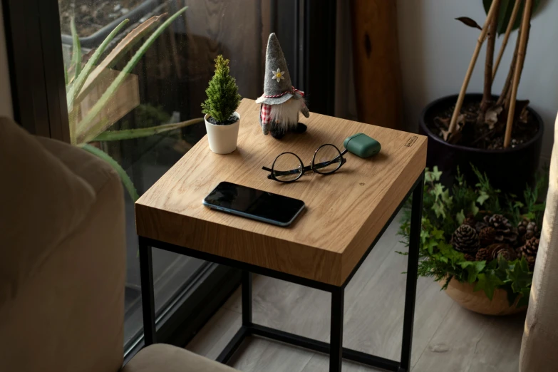 the table is made out of an oak board with a mobile device on top