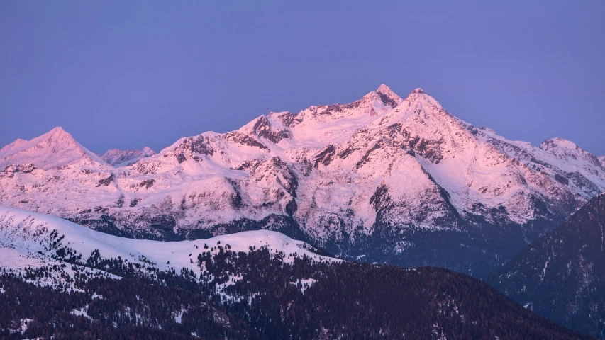 the view of the snow capped mountain ranges at dusk