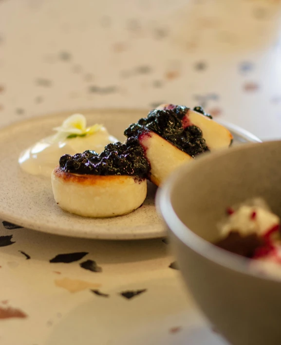 two pieces of cake on a plate near a bowl