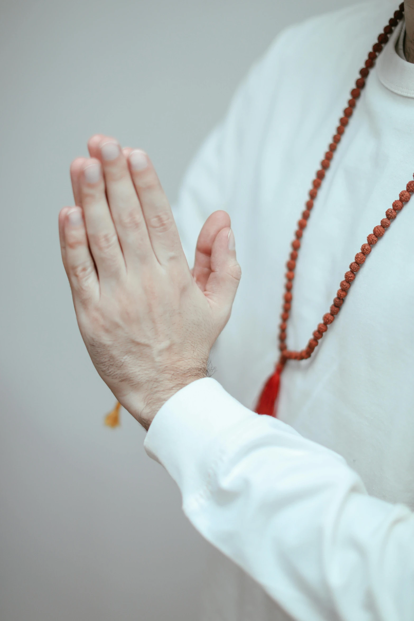 a man in a white shirt holding his hands together