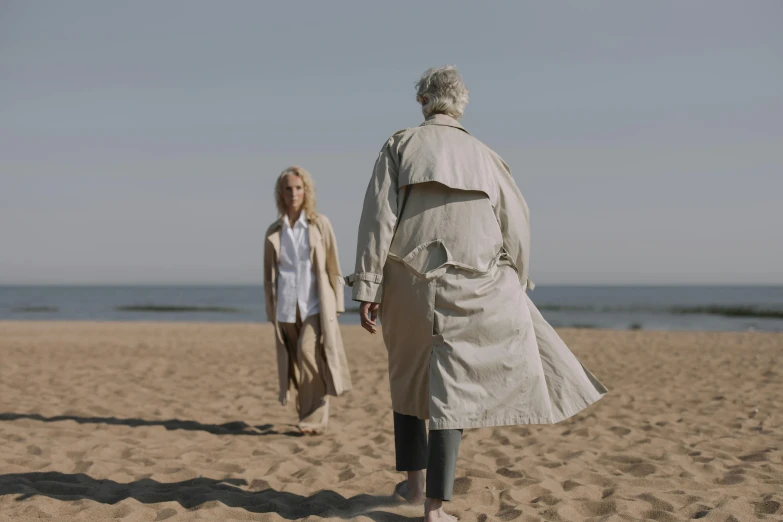 a lady walking next to an older lady on the beach