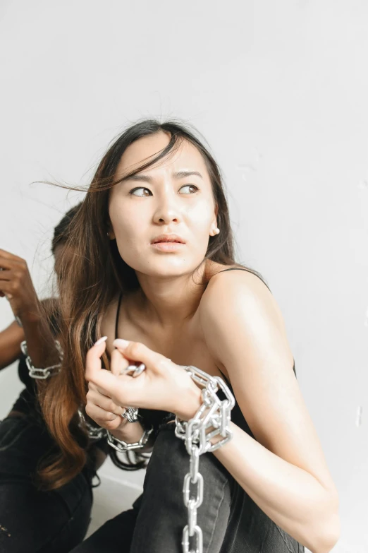 a young woman is sitting with her hand in a  chain