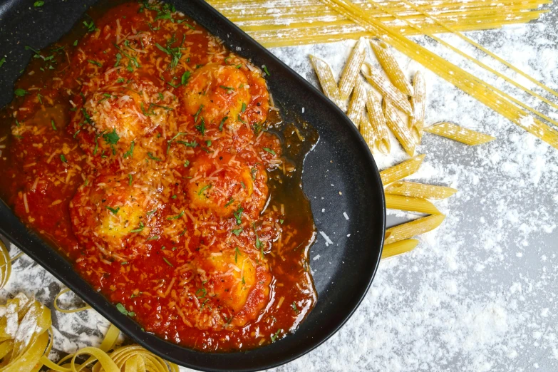 a large dish is covered with noodles and meatballs