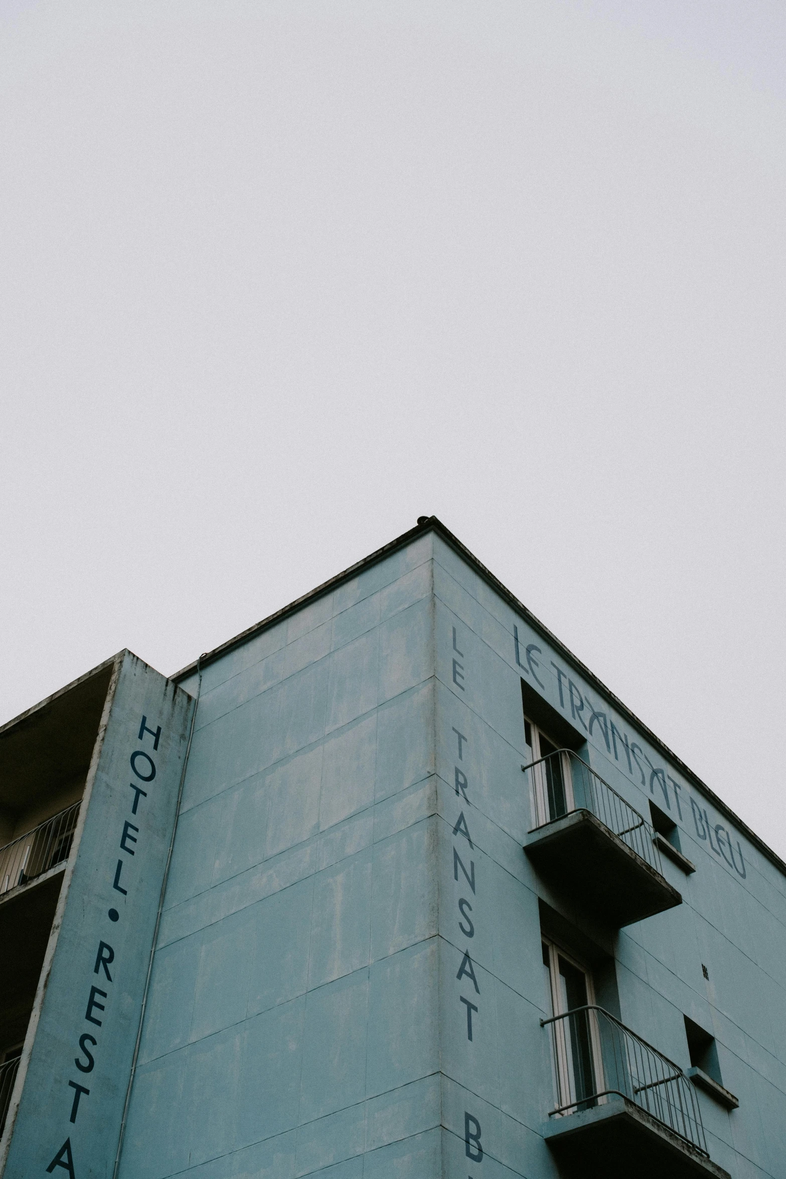 the side of a building with two stories with graffiti on them