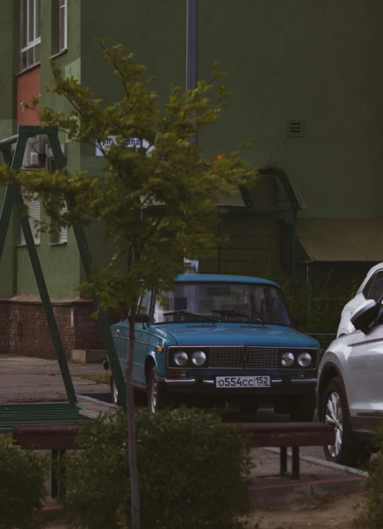 two cars parked outside next to a building and green roof