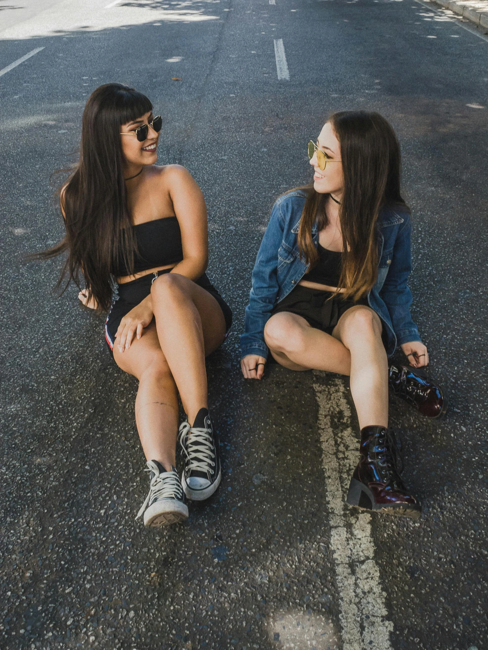 two girls sitting on the road having fun