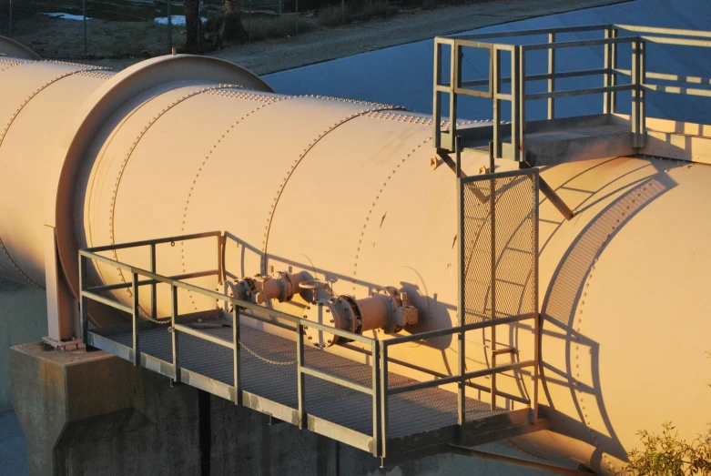 industrial tanks sit near a road at dusk