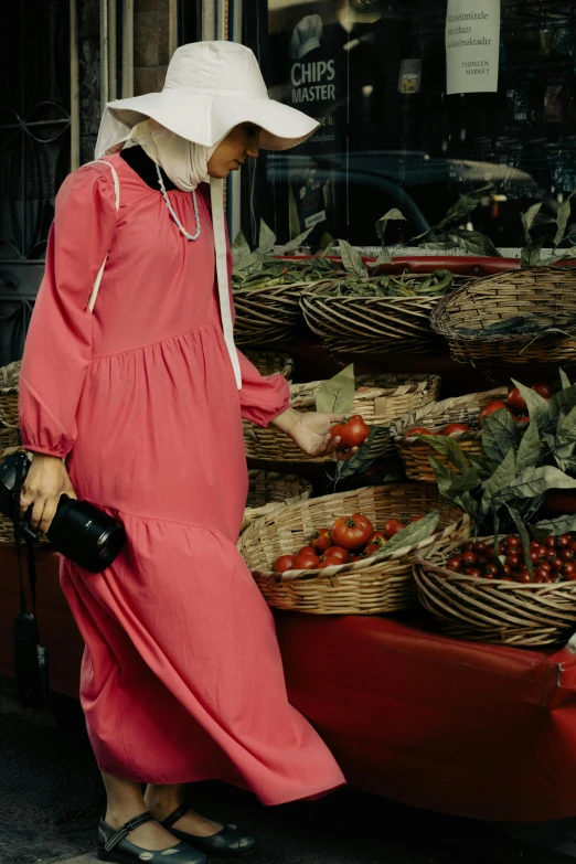 the woman in red is walking outside by many baskets