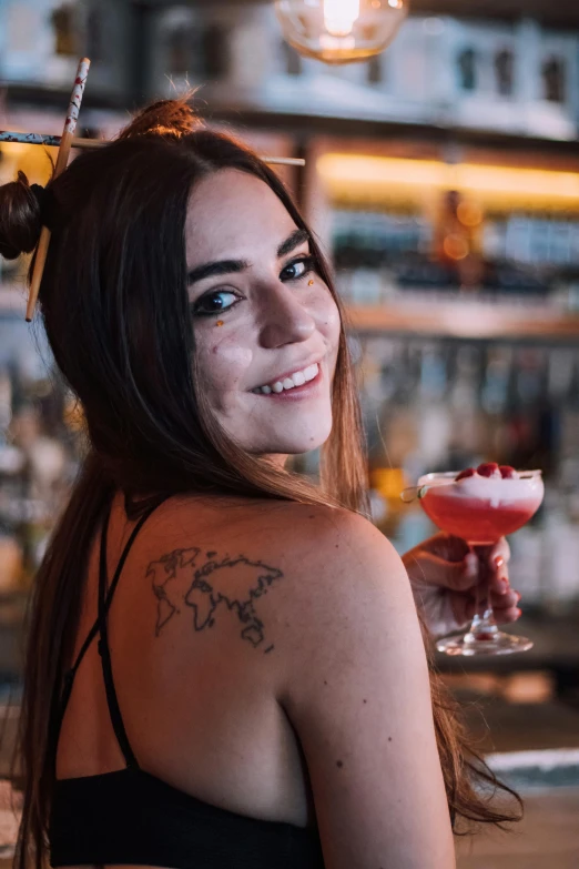 a woman with some tattoos and a drink