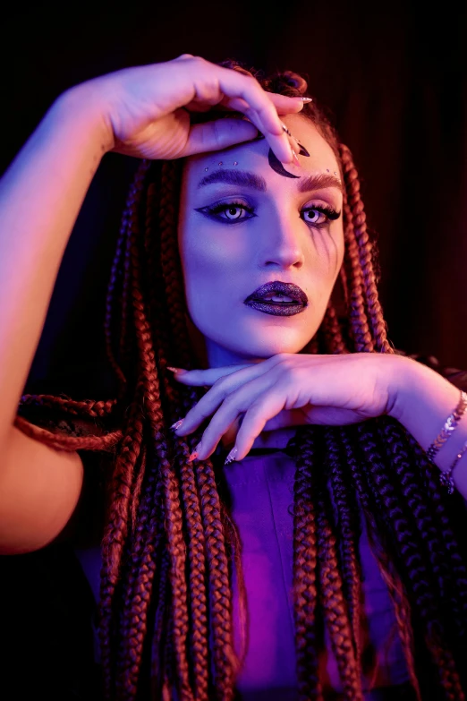 a girl with white face paint and black makeup, stands in front of a dark background