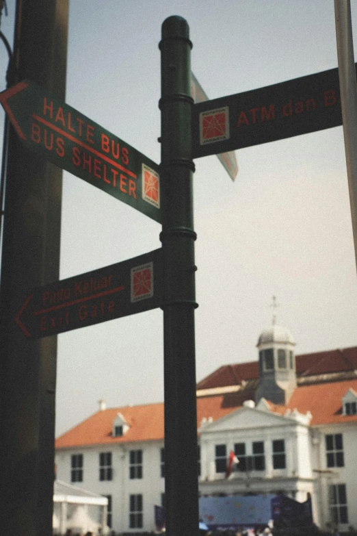 the corner of a street with street signs and a white building