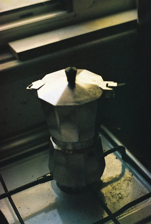 an iron pot on a stove top with a window behind it