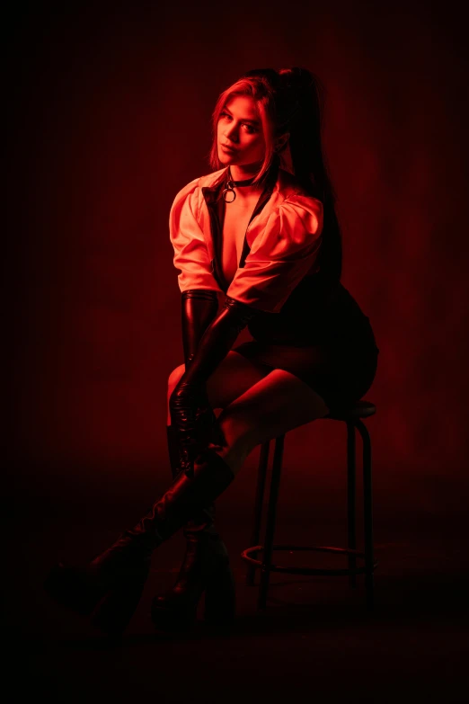 a woman in a red shirt is sitting on a stool