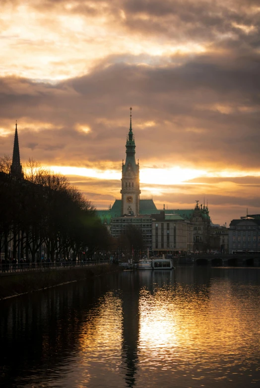 a clock tower sitting above water with other buildings behind it