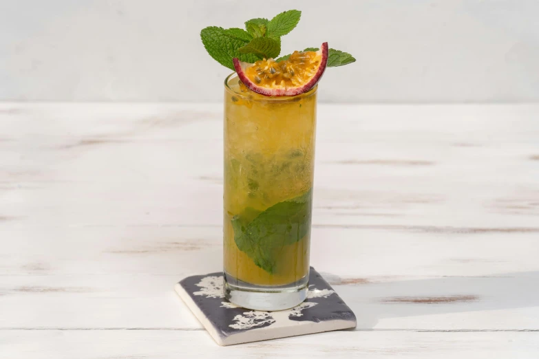 a tall drink with a slice of orange and mint