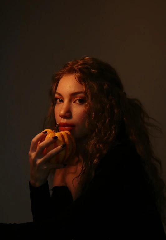 a woman with curly hair is holding a piece of food