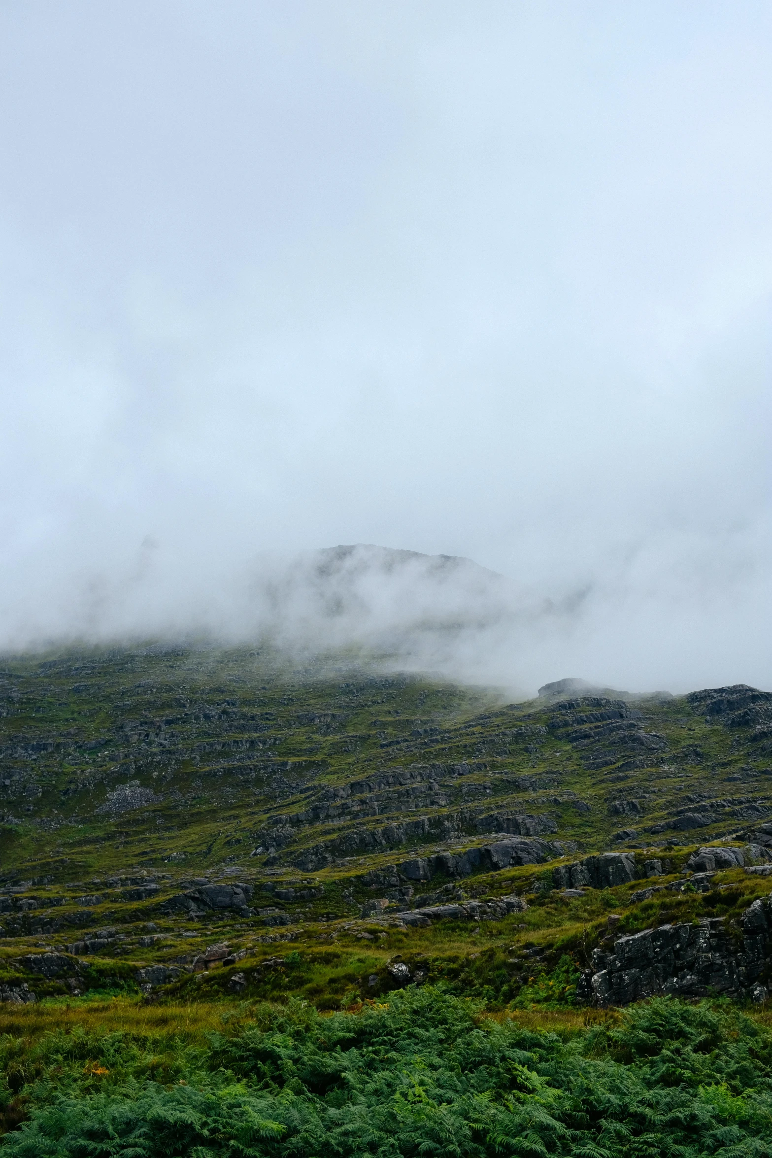 a large mountain with some grass on the ground