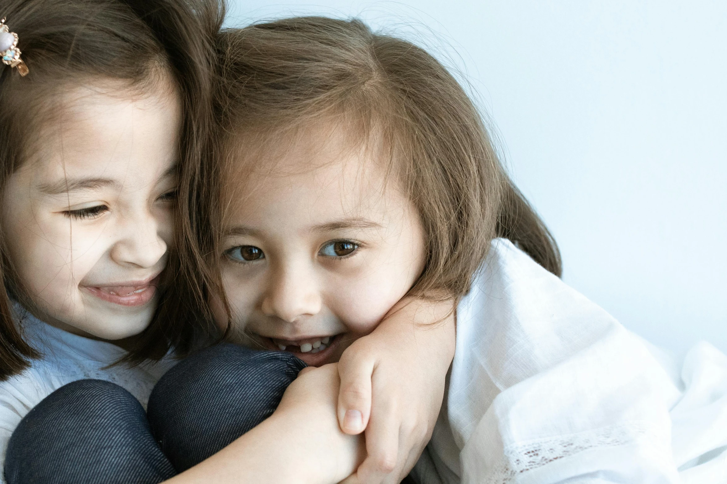 two young children hugging each other with their hands