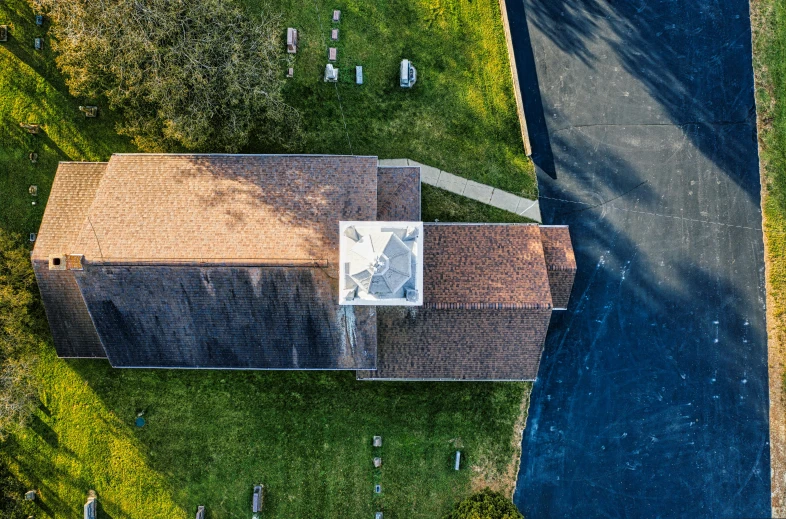 a black road and some grass and a brown roof