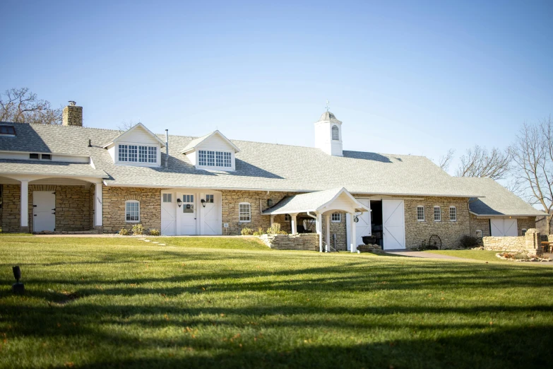 a large white house with a tall grass front yard and trees