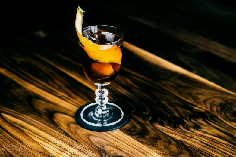 a glass filled with liquid and ice in the shape of a lemon slice on a wooden table