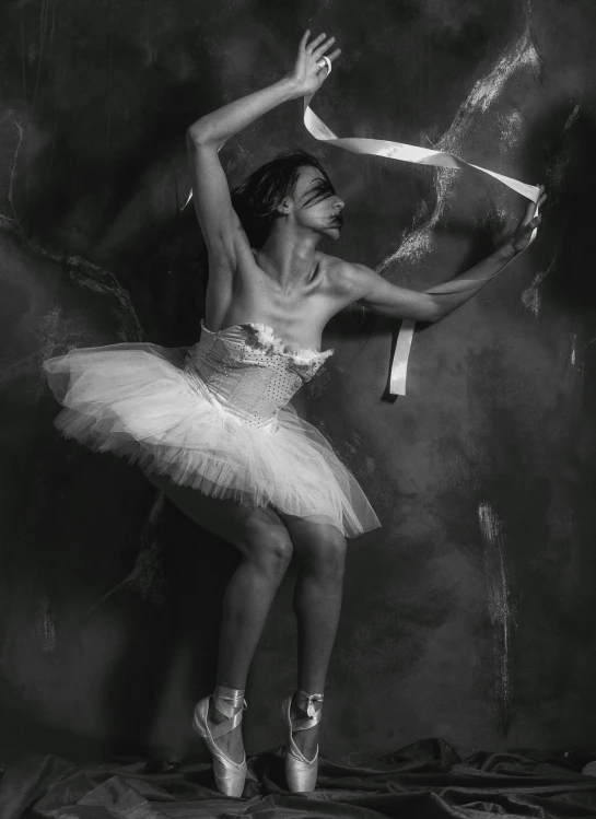 a young ballerina performing on stage with a piece of fabric in her hand