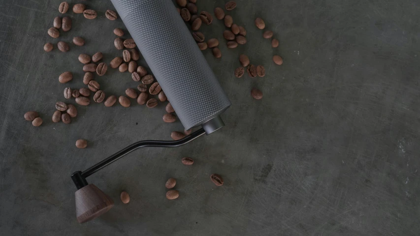 a cup, some nuts and a coffee mug on a grey surface