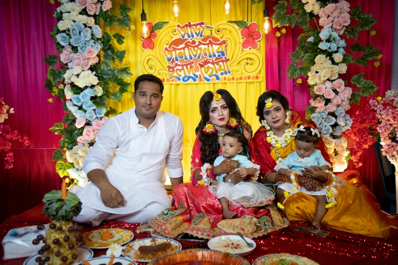 people dressed in traditional indian clothing and food are posed for a family po