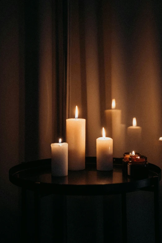 a collection of lit candles sitting on a table