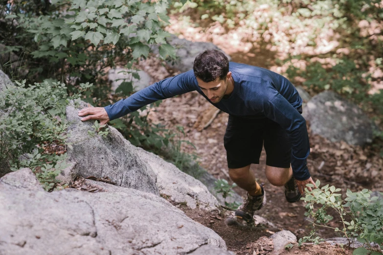 a man in running gear climbing up a mountain