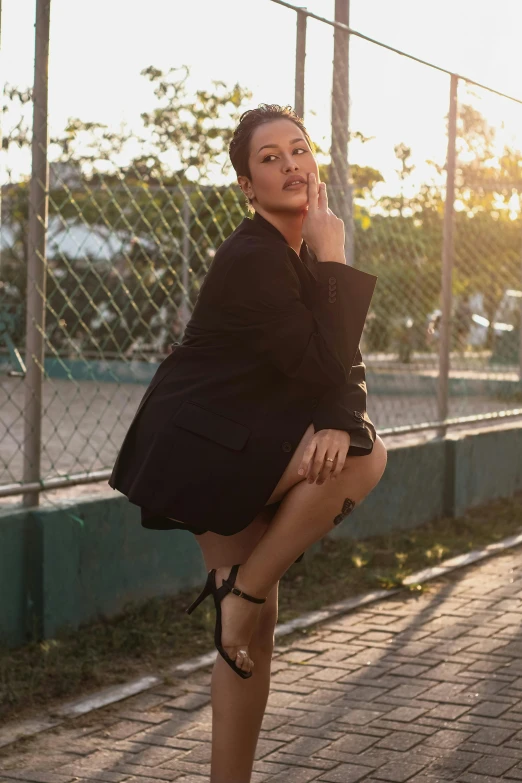 a woman with very high heels posing in front of a fence