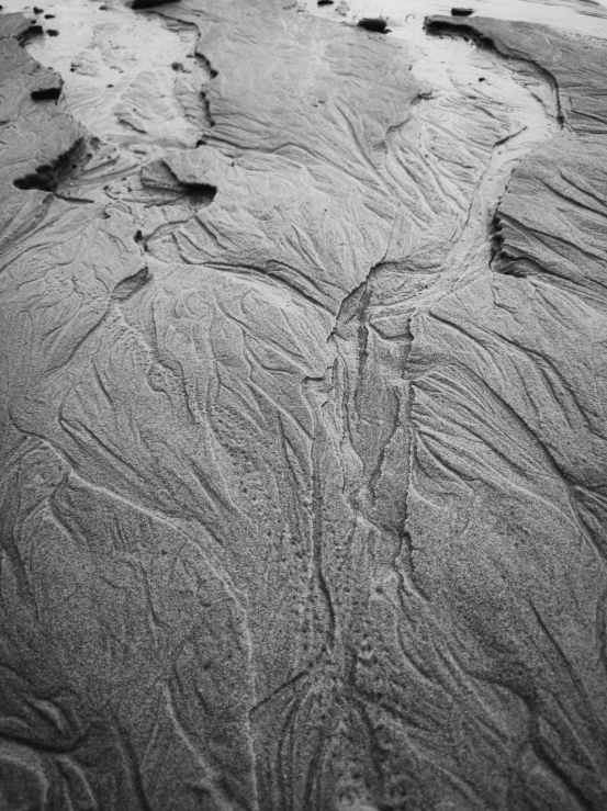 sand pattern on the beach with rocks near it