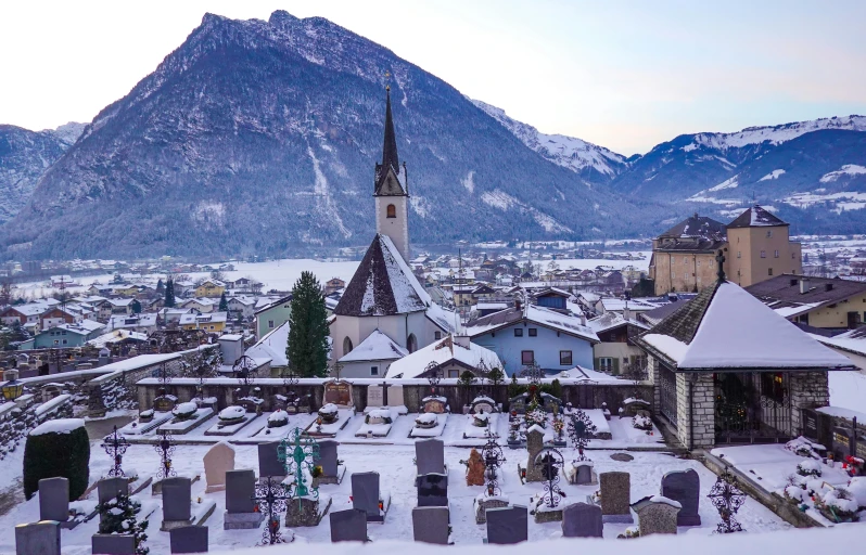 a snowy village near the mountains with lots of buildings