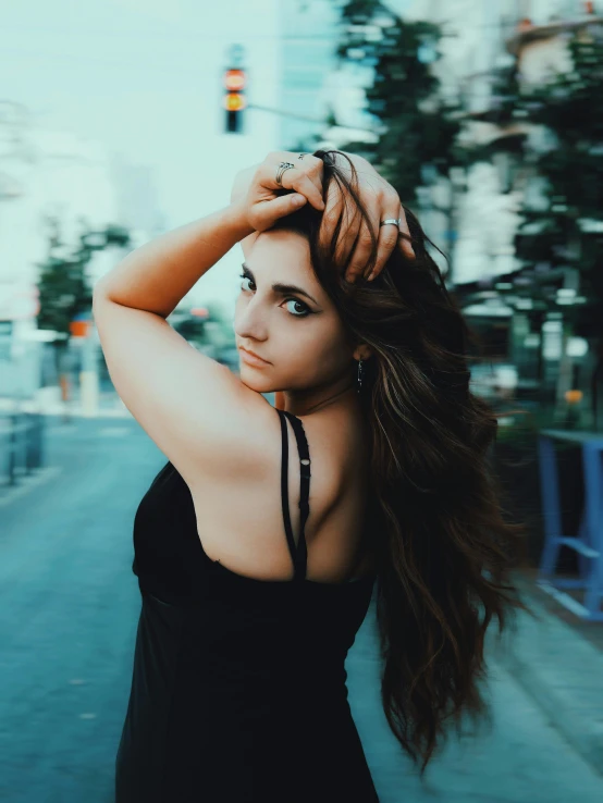 a beautiful woman posing on a city street