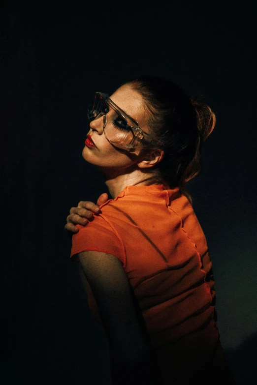 a woman wearing glasses and an orange dress