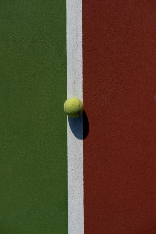 a tennis ball is sitting on the side of a court