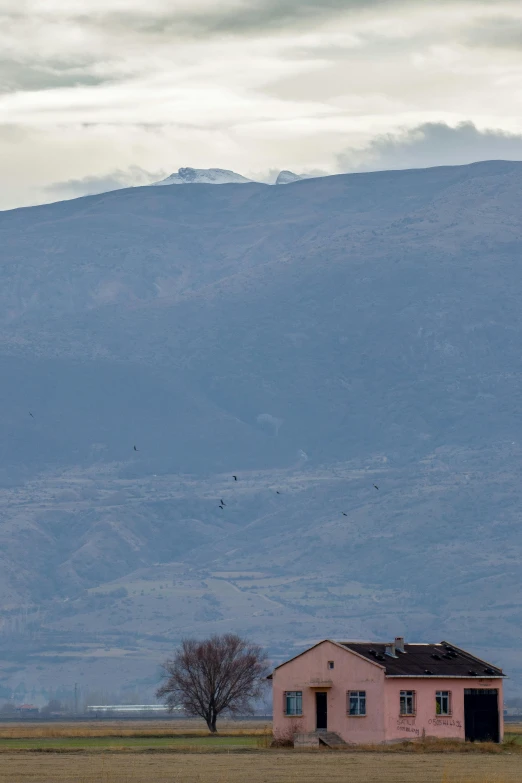 the lone house is sitting on the empty grass