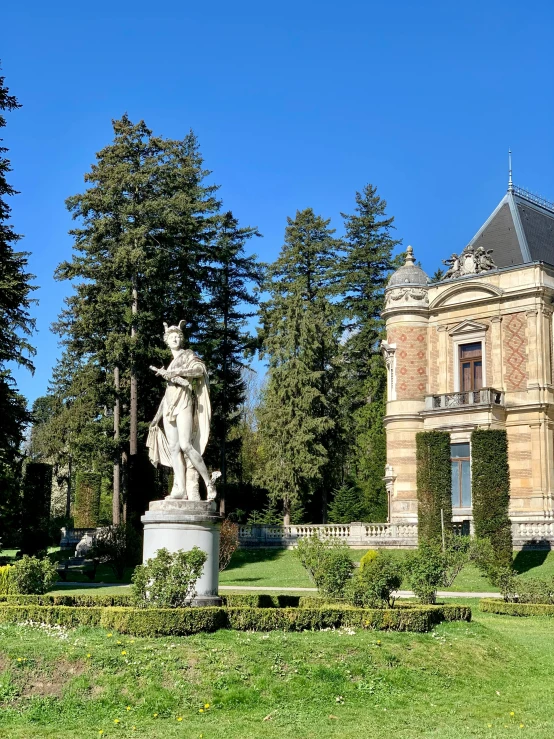 a statue in front of a castle in a park