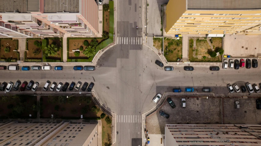 an overhead s of an intersection, with parking and cars parked along it