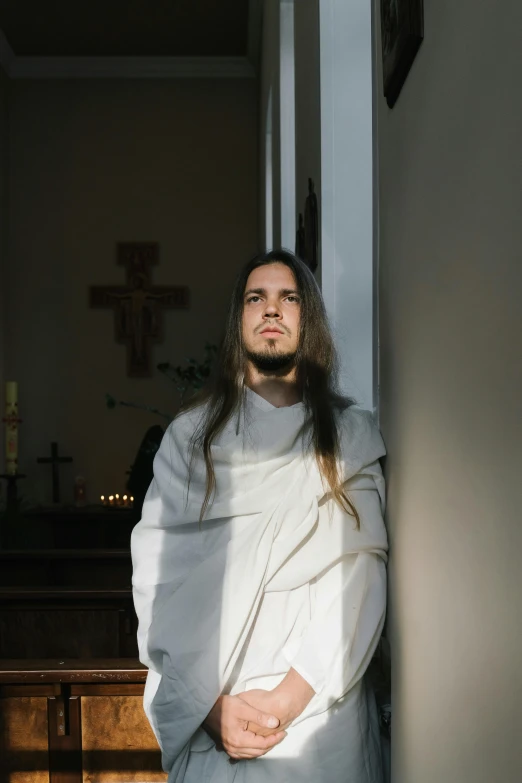 a man standing in front of a wooden cross