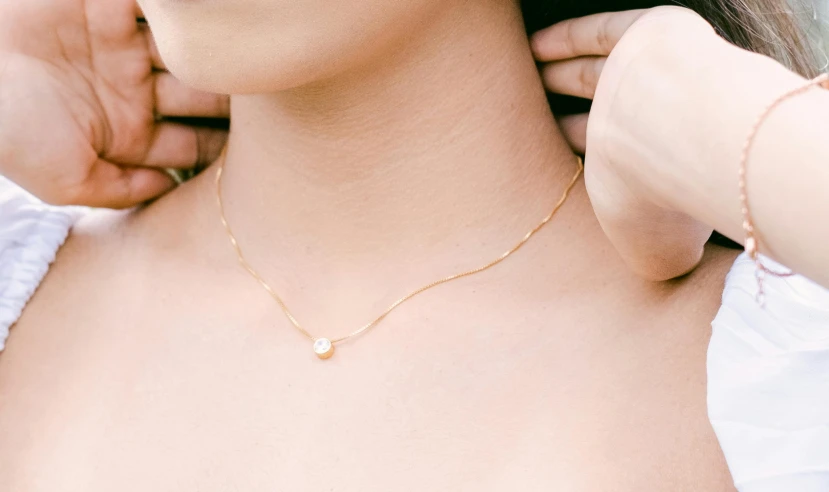 a woman wearing an unmade gold necklace
