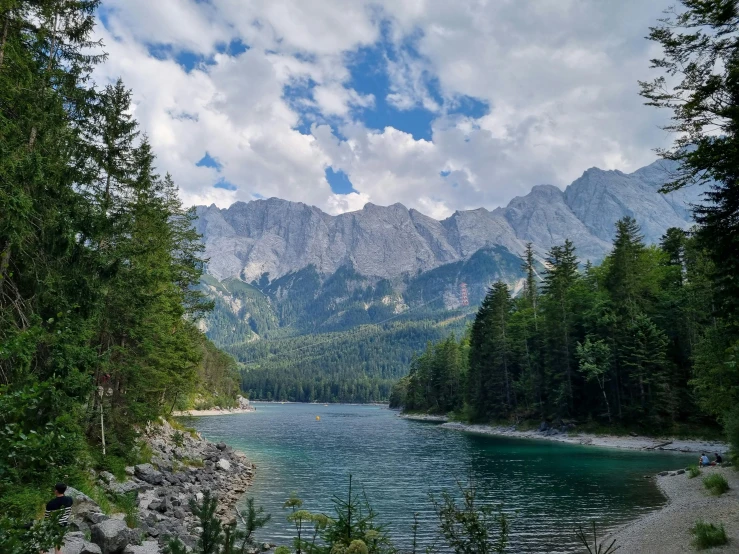 the mountains surrounding a lake with small waves in it