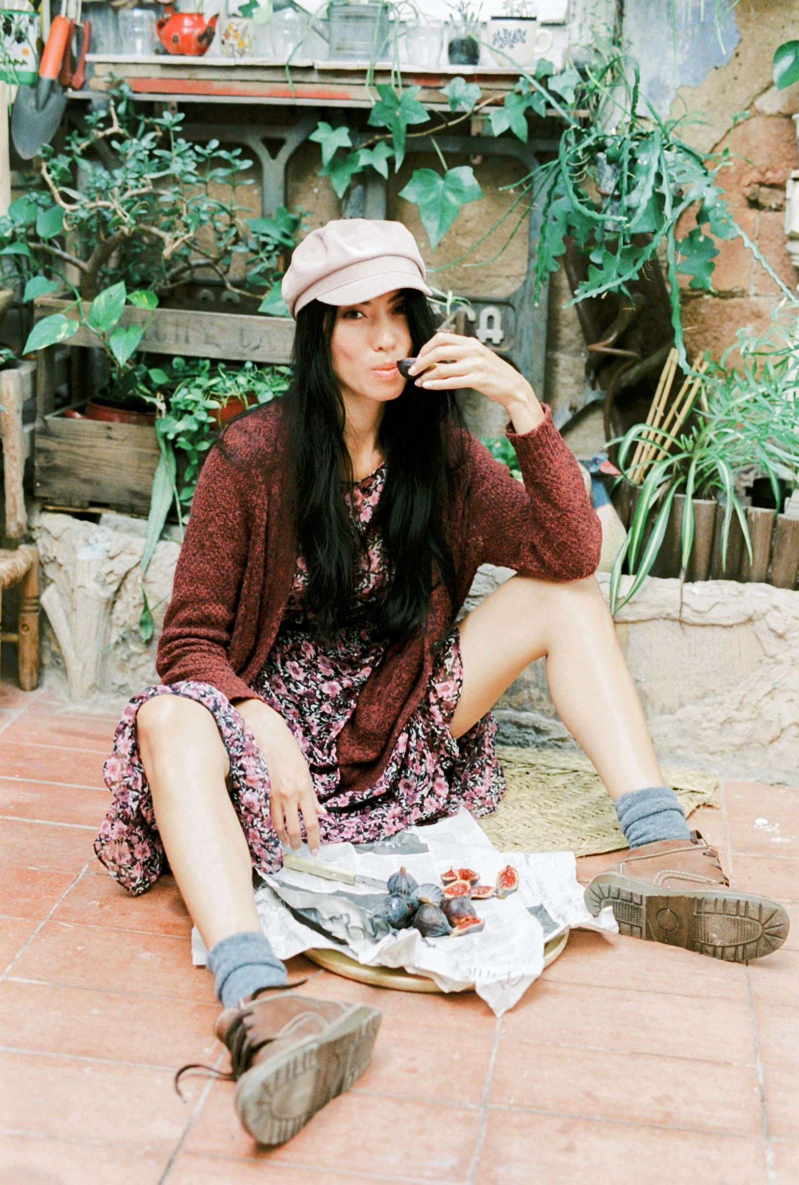 a woman sitting on the ground talking on a cell phone