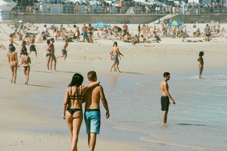 some people and a beach some sand and water