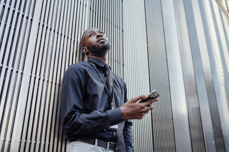 a man stands on the side of the wall and checks his phone