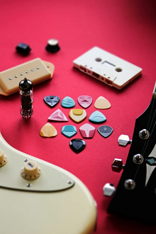 a close up of a guitar, musical instrument, and magnets on a red surface